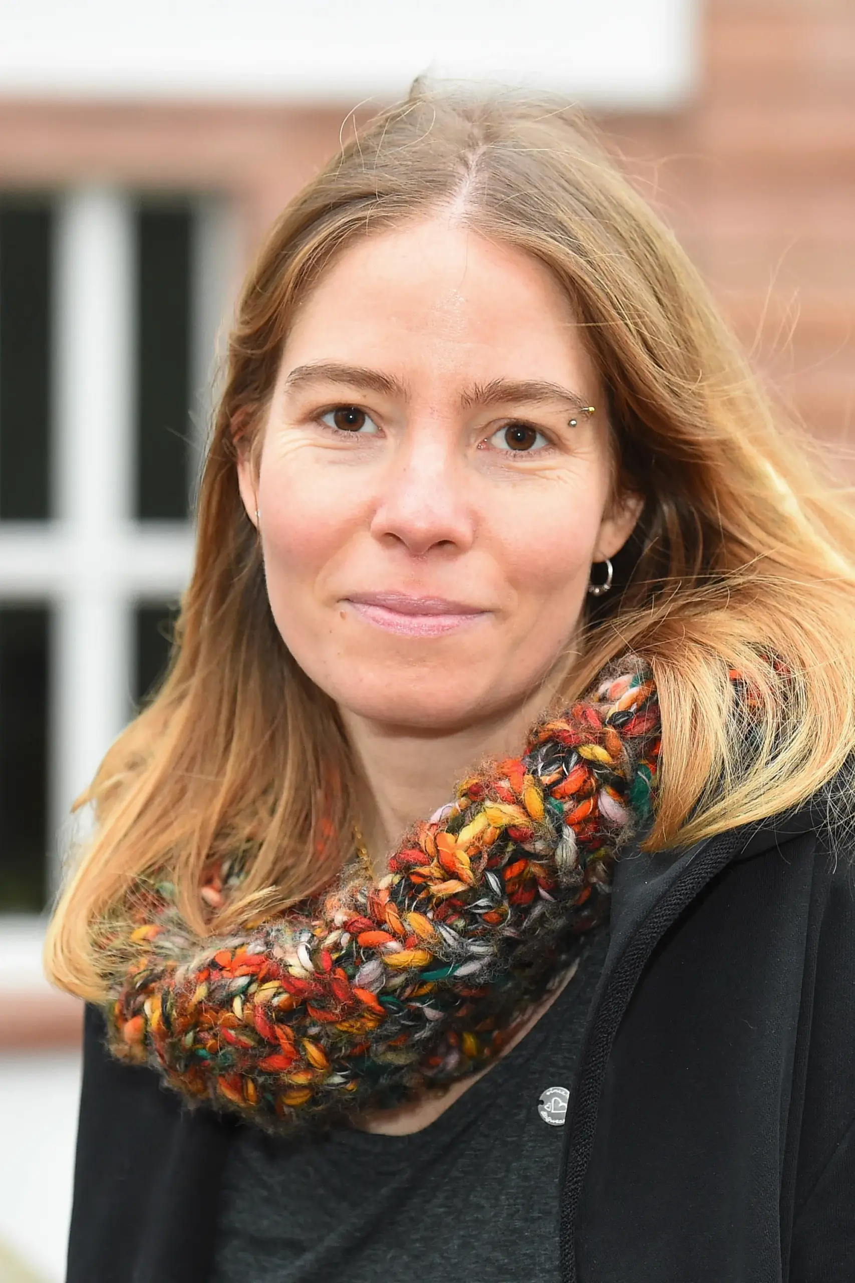 Porträt von Pia Ditscher, Projektleiterin von UrbanWild, im Außenbereich mit unscharfem Gebäudehintergrund